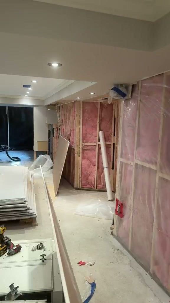 Basement walls framed and filled with pink insulation behind a vapour barrier