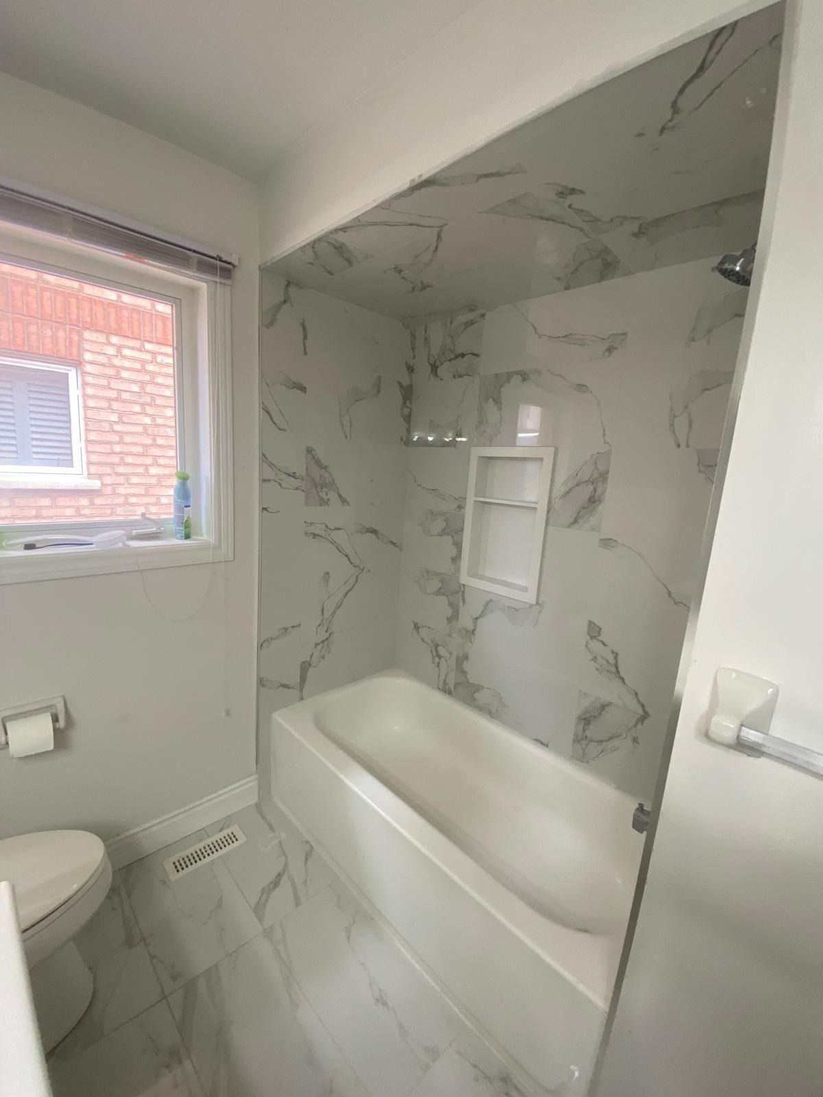 Bathroom with marble-look porcelain on the walls and ceiling around a white tub