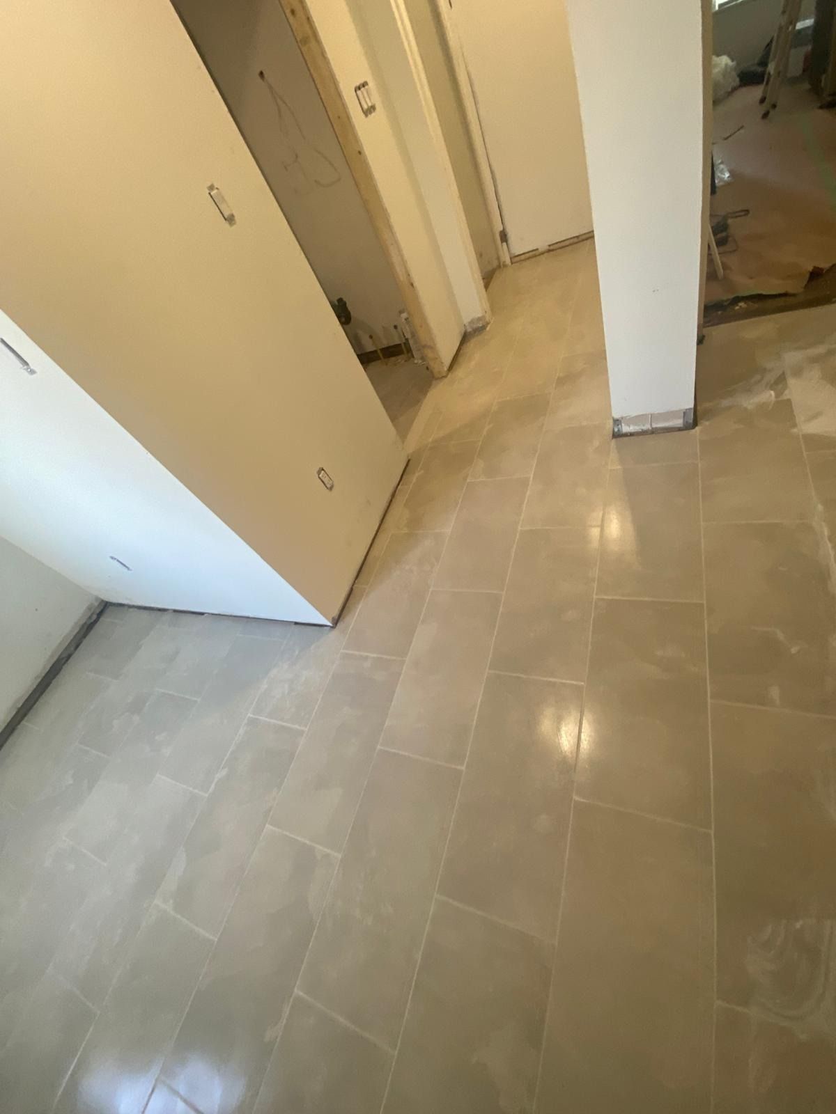 Large grey porcelain plank tiles laid through a hallway